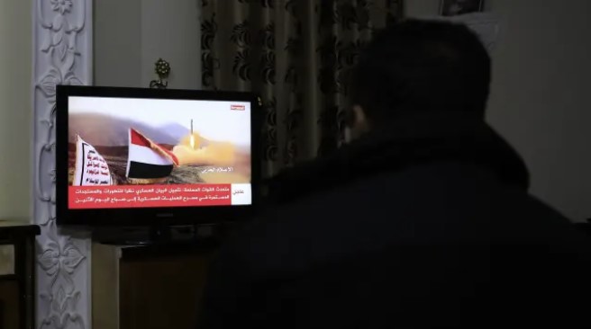 Una persona mira las noticias en un canal dirigido por hutíes después de que un barco de Reino Unido fuera atacado en el Mar Rojo, en Saná, Yemen, el 19 de febrero de 2024